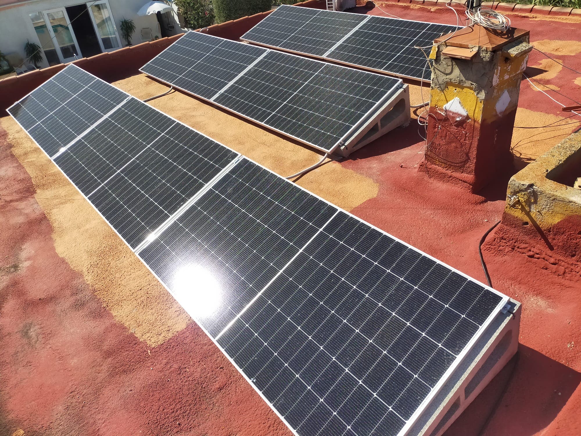 Panels mounted on a terracotta roof terrace, catching the midday sun